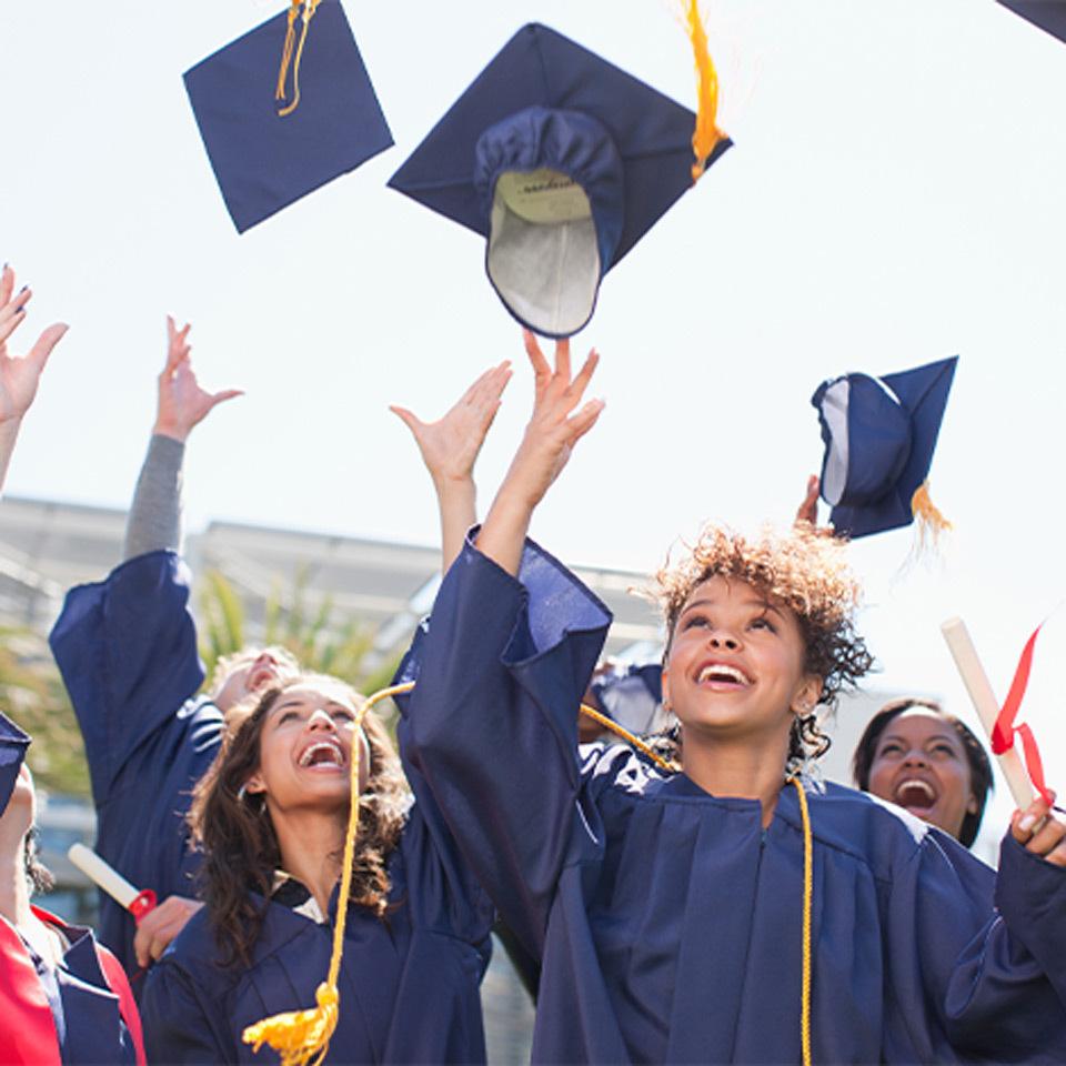 Recent graduates throwing their caps